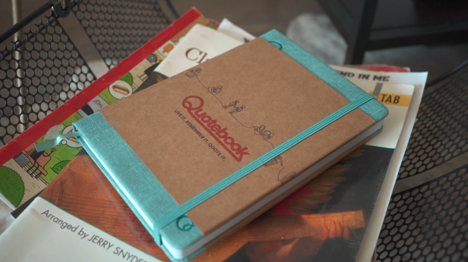 Quotebook resting on a table with other books